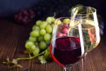 Gläser mit Rot- und Weißwein mit Trauben