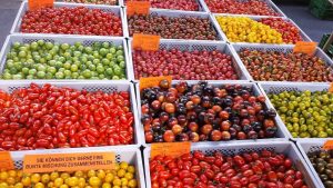 Marktstand-mit-verschiedenen-Sorten-Tomaten
