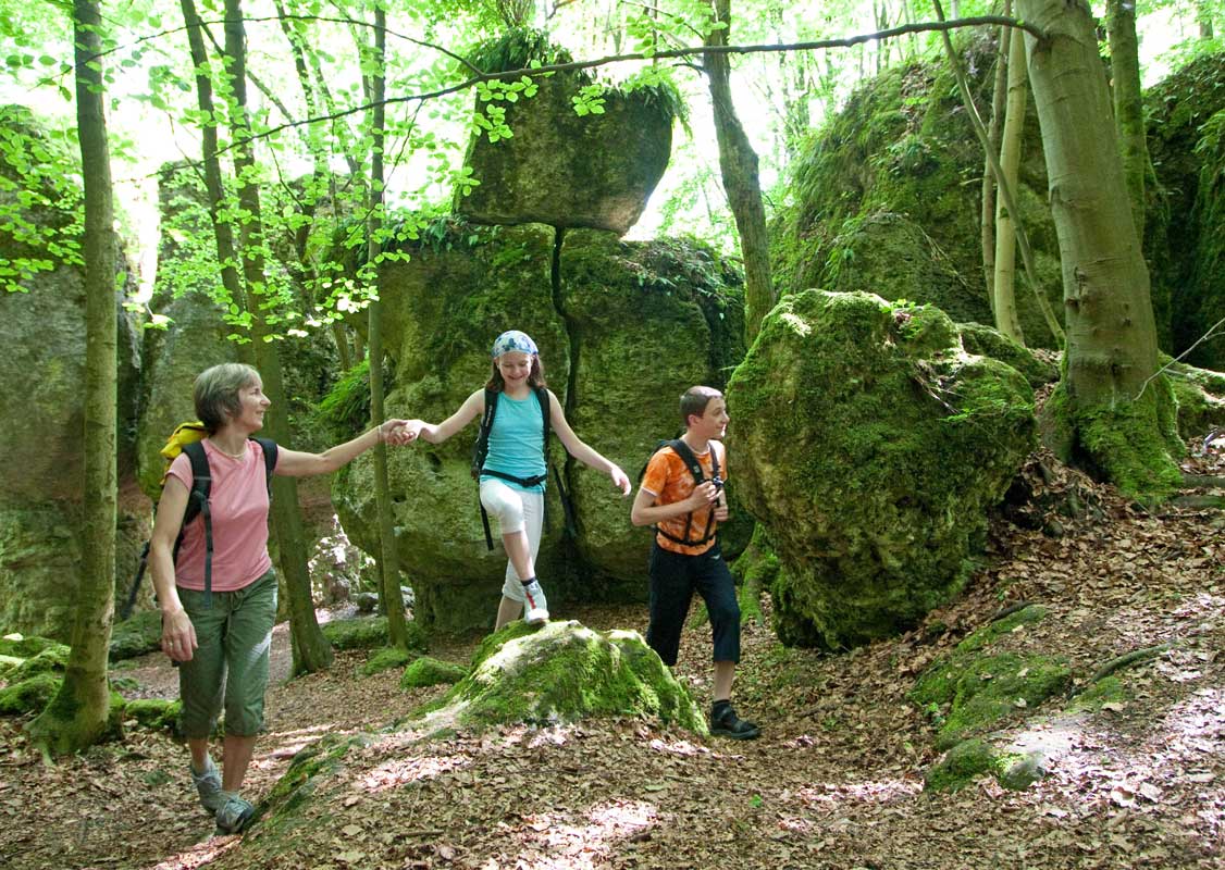 Wanderer unterwegs auf dem Erzweg bei der "Steinernen Stadt", einer beeindruckenden Felsansammlung im Wald nahe Auerbach