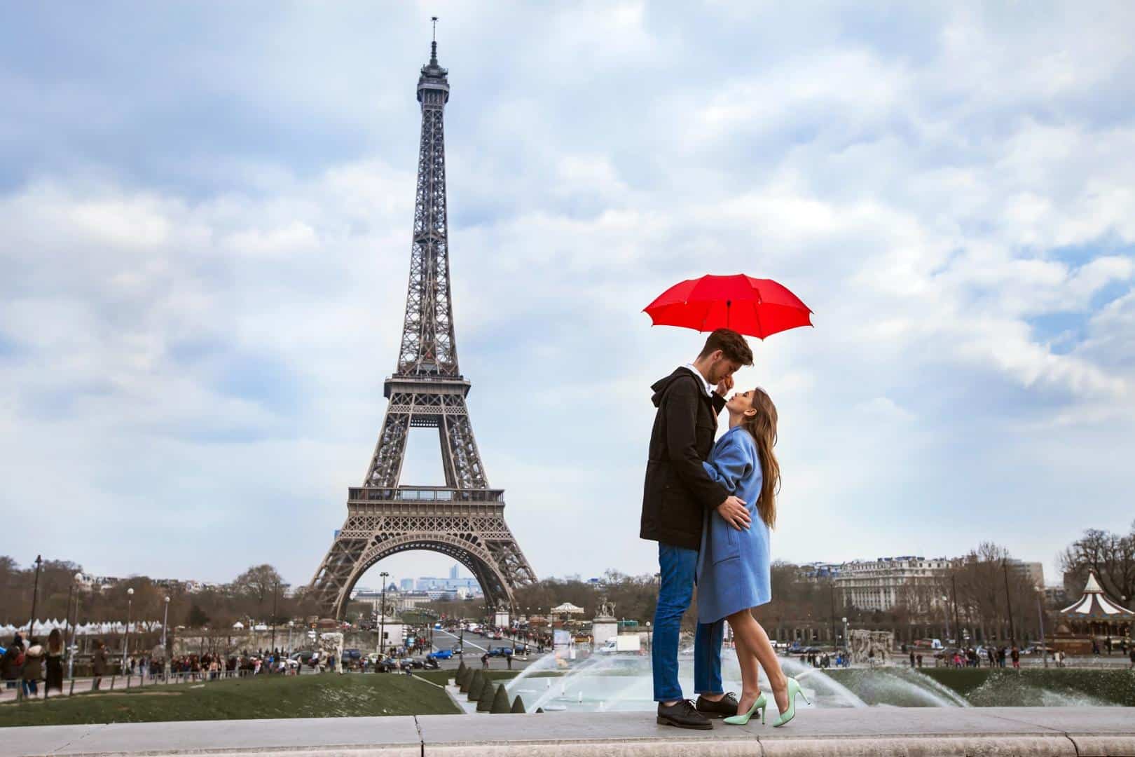 Paar mit Regenschirm vor dem Eiffelturm - Paris gehört zu den romantischsten Städten Europas