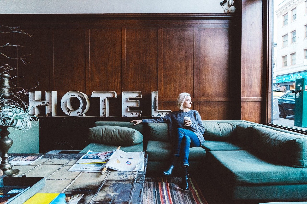 Frau in Hotellobby schaut aus dem Fenster - Onlinemarketing