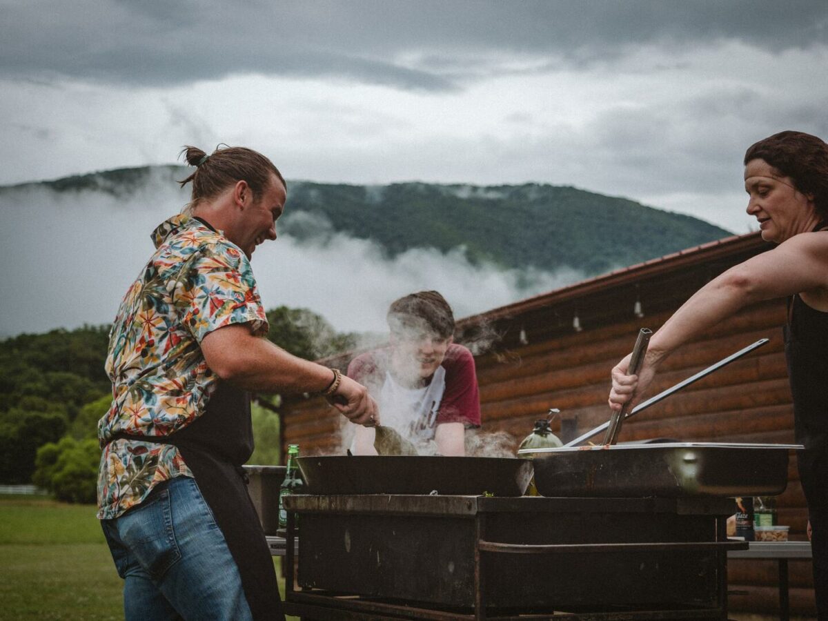 Drei Freunde grillen auf einem großen Grill im Freien