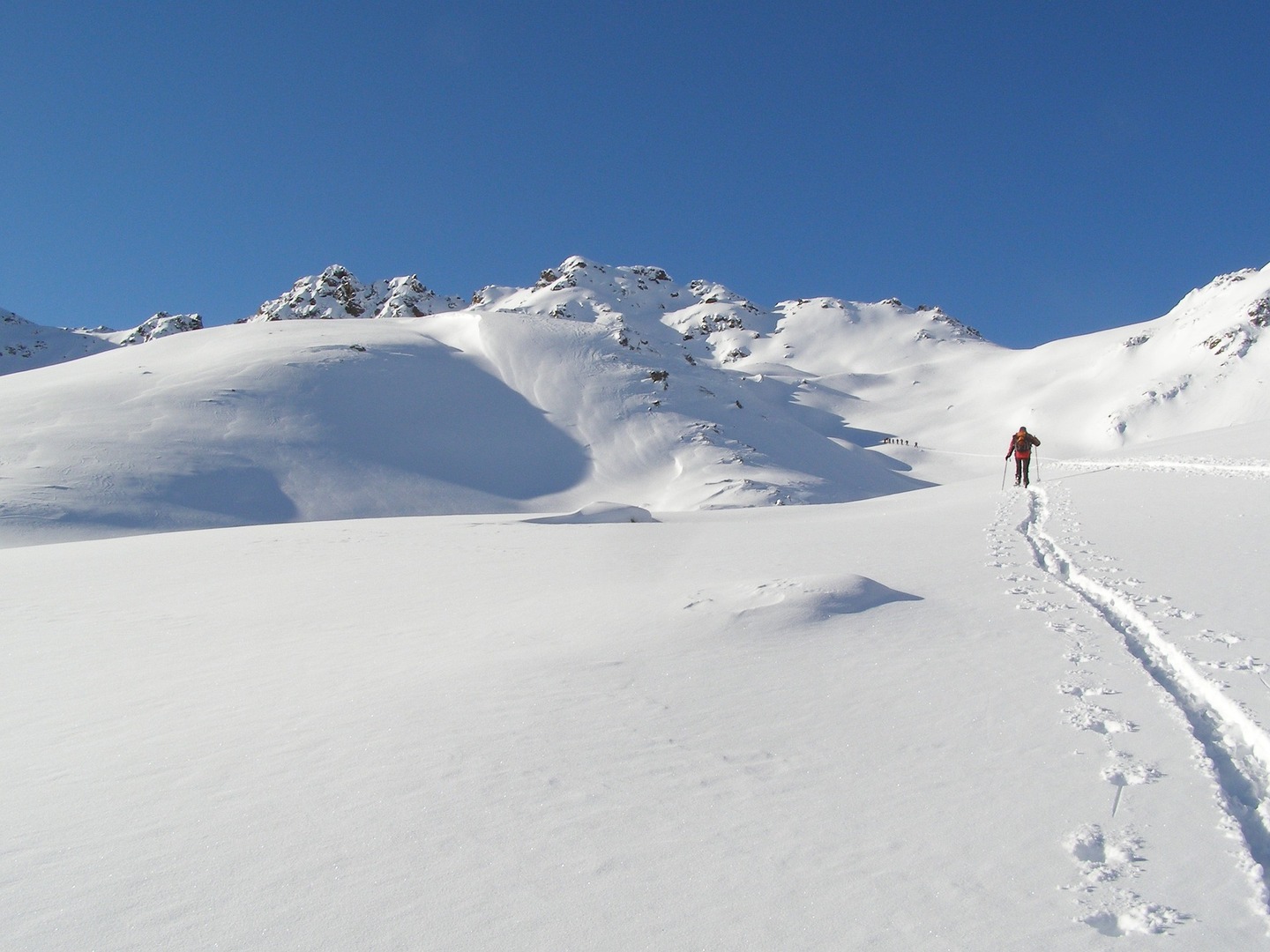 einsamer Skilangläufer in verschneiter Gipfellandschaft