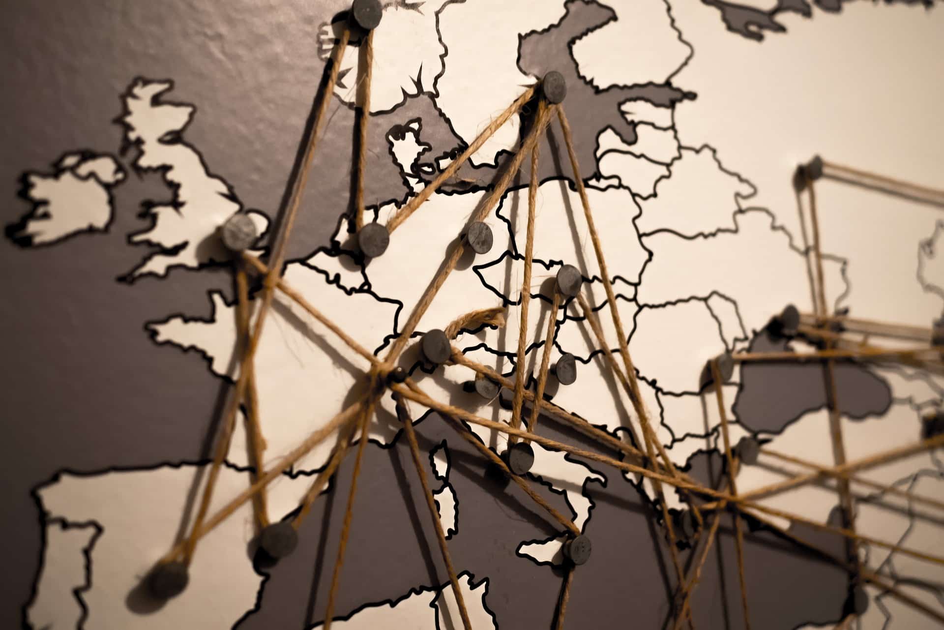 Europakarte mit Pins verbunden mit Schnur