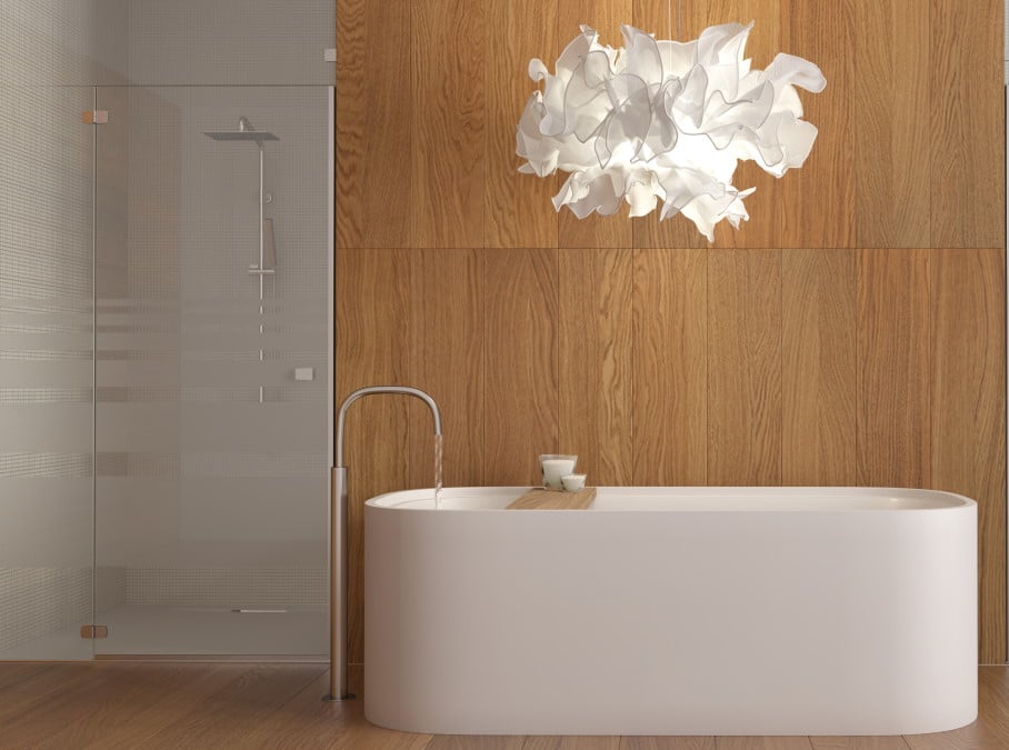 Badezimmer mit freistehender Wanne vor Holzwand und durch Glastür abgetrennt Dusche