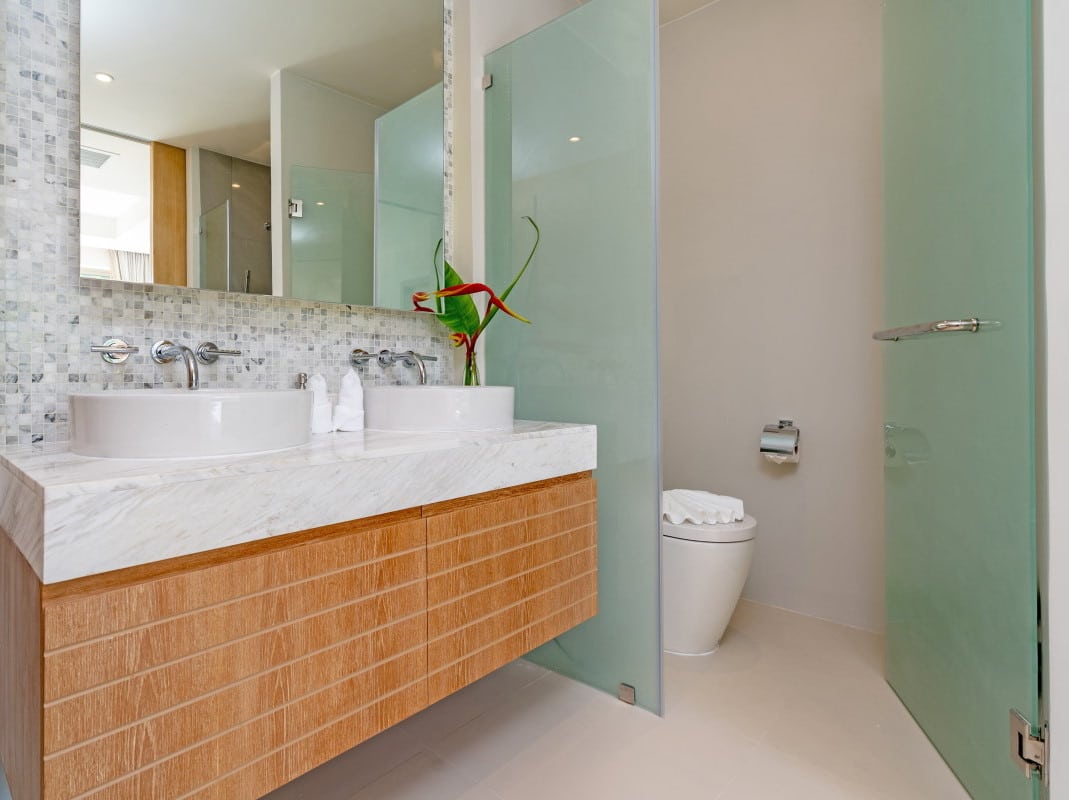 Modernes Badezimmer mit Toilette hinter Milchglastür