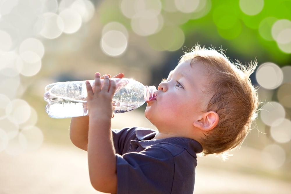 Junge trinkt aus einer Wasserflasche
