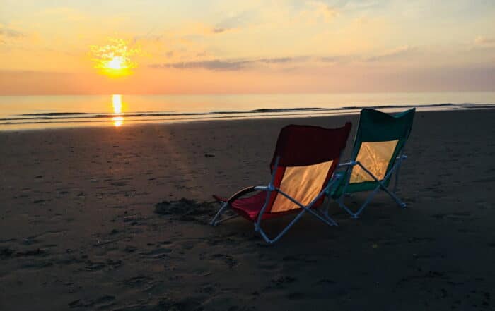 Sonnenuntergang an der Nordseeküste 2 leere Campingstühle am Strand