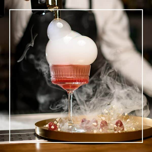 Rosefarbener Cocktail mit Rauch und Schaumblasen