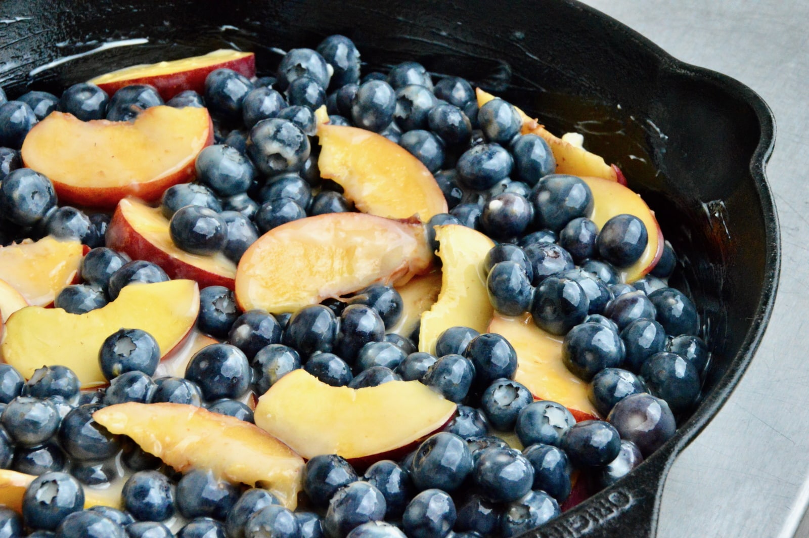 Blaubeeren und Nektarinen in einer Gusspfanne