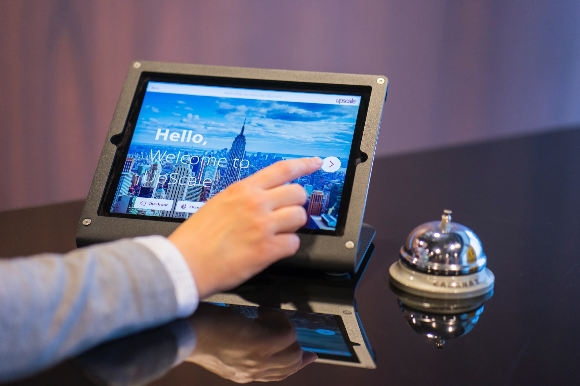 Hotelmitarbeiter bedient Tablet an der Rezeption eines Hotels