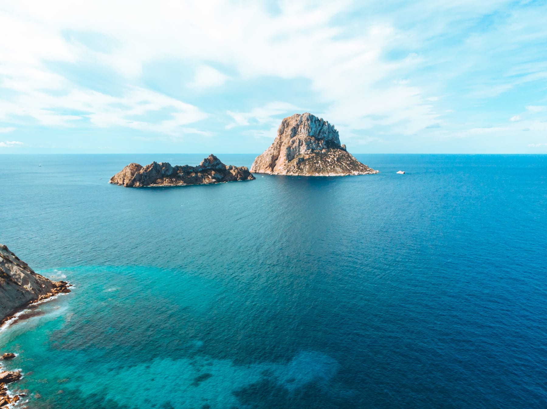 Blick über türkisfarbenes Wasser auf Inseln vor Ibiza