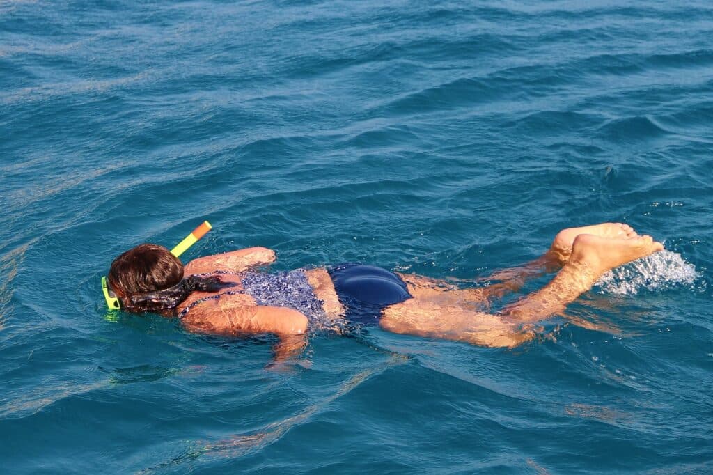 Junge Frau schnorchelt in klarem blauen Wasser