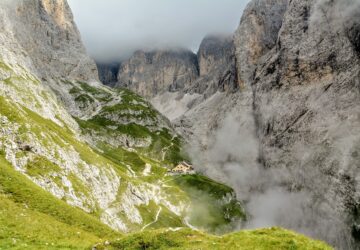 Wanderpfad in den Dolomiten zur Grasleitenhütte oder Refugio Bergamo die markanten Berggipfel liegen im Nebel, am Ende des Pfads liegt eine Steinhütte