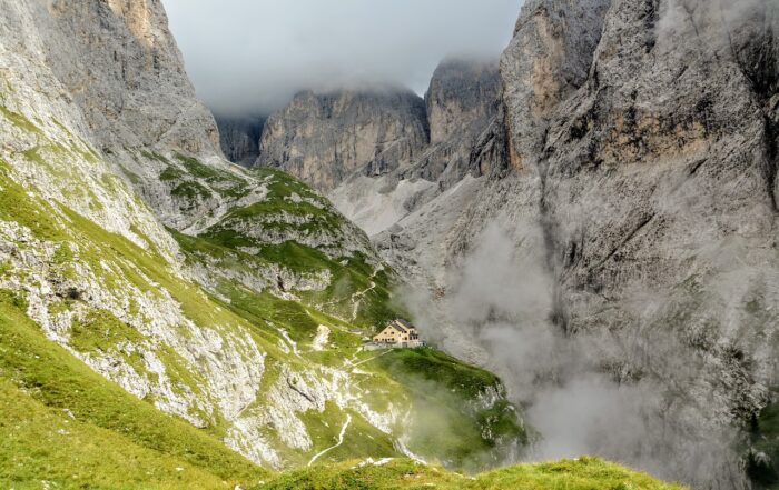 Wanderpfad in den Dolomiten zur Grasleitenhütte oder Refugio Bergamo die markanten Berggipfel liegen im Nebel, am Ende des Pfads liegt eine Steinhütte