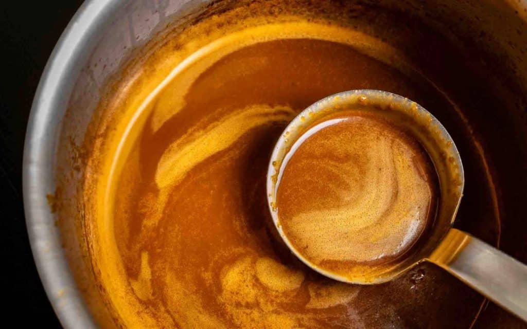 luxus-gourmet-rezept-demi-glace-thomas-sixt-fuer-varta demi-glace Soße in einem Topf mit Schöpfkelle