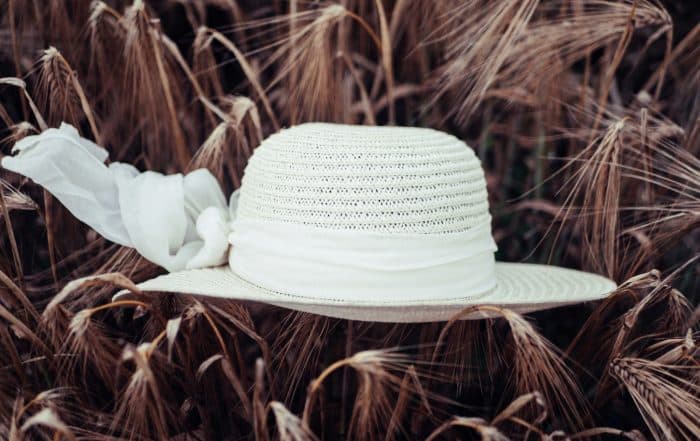 Weißer Strohhut mit weißem Band auf Gerstenähren