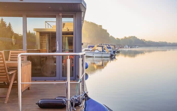 houseboat on a river in a early sunny morning. floating house is a pleasant place for rent for weekend