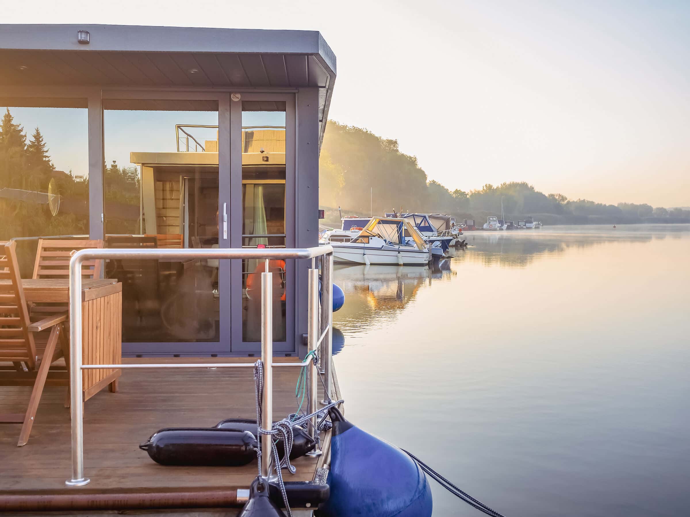 houseboat on a river in a early sunny morning. floating house is a pleasant place for rent for weekend