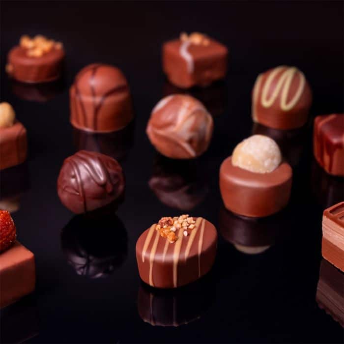 1000_nuss_nougat_pralinen_schokoladen_nussig_2 Verschiedene Pralinensorten auf dunklem Untergrund.