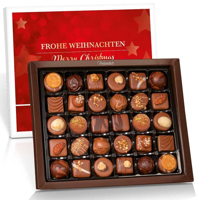 nn_frohe_weihnachten_30er_pralinen_geschenk Rote Pralinenverpackung im Hintergrund, im Vordergrund offene Pralinenschachtel mit 30 Pralinen.