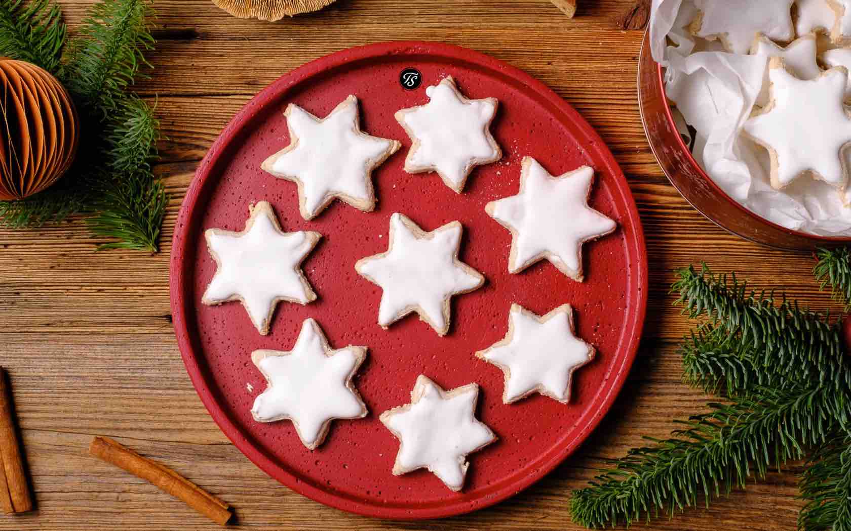 Zimtsterne von Thomas Sixt auf rotem Teller auf Holztisch