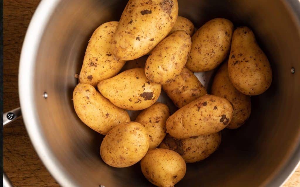 Rohe ungeschälte Kartoffeln in einem Edelstahltopf