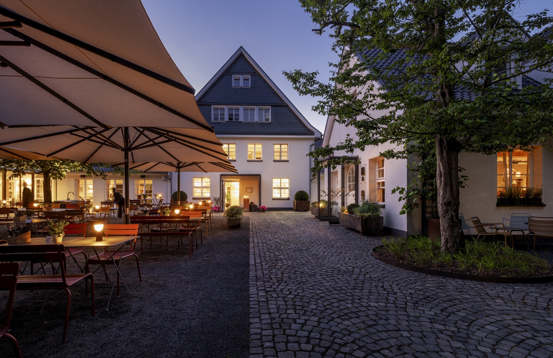 Abendaufnahme Innhof mit Restaurantterrasse in der Diepeschrather Mühle