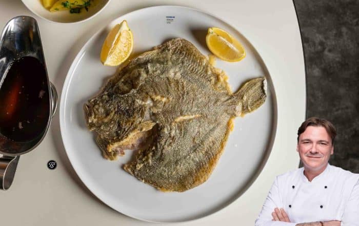 Gebratener Steinbugg mit Zitronenvierteln auf weißem Teller mit Portraitfoto von Thomas Sixt