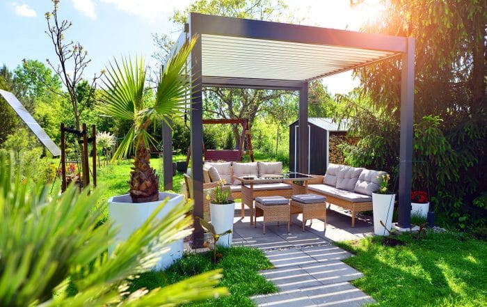 moderne Pergola in grünem Garten mit Sitzecke