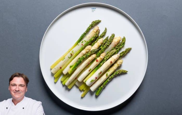 weißer Teller mit grünem und weißem Spargel auf dunklem Hintergrund mit Portraitfoto von Foodblogger Thomas Sixt
