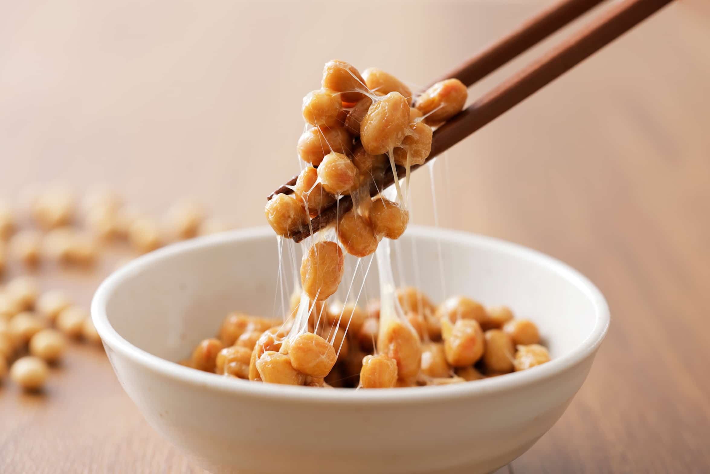 Fädenziehen inklusive – Natto ist nichts für empfindliche Genießer Natto Gericht aus Japan mit fermentierten Sojabohnen, die beim Aufnehmen mit Stäbchen lange Fäden ziehen