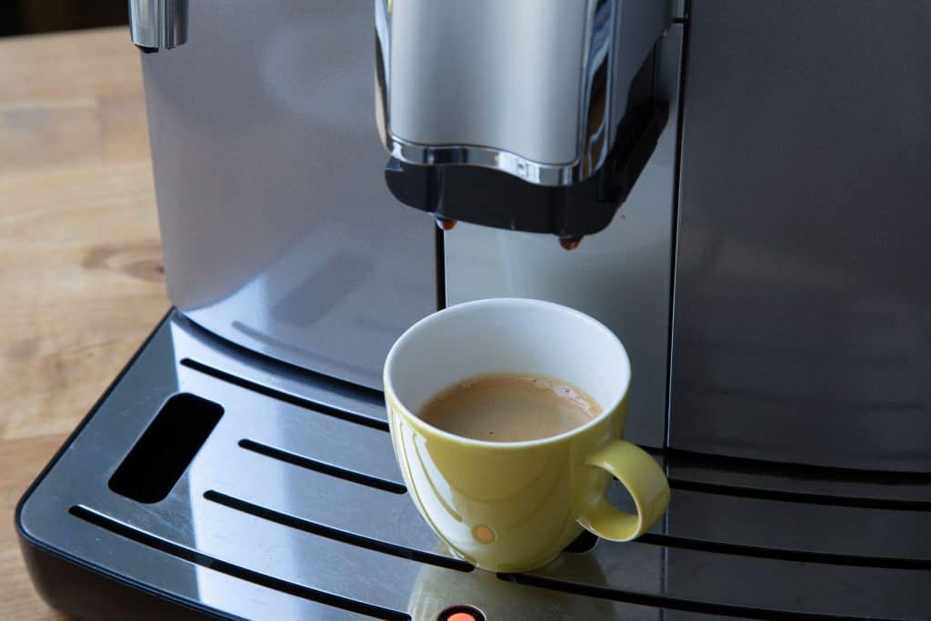 Vollautomat Detailaufnahme grüne Kaffeetasse unter Vollautomat halb gefüllt mit Kaffee