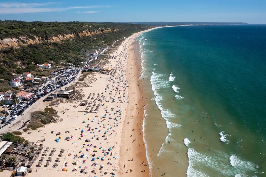 Aerial view of Praia de Fonte da Telha beach with coastline and ocean waves Aerial view of Praia de Fonte da Telha beach with coastline and ocean waves