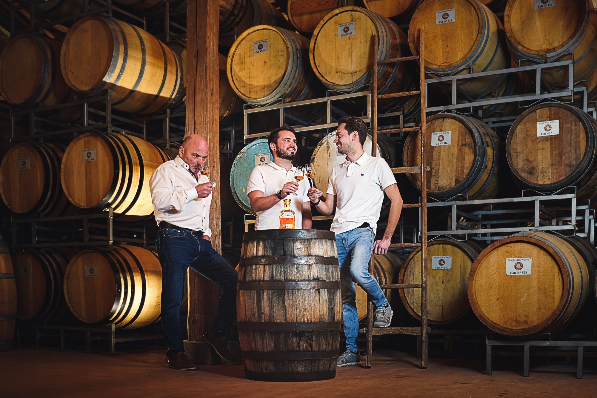 Brigantia Whisky Destillerie - Tasting Familie im Whisky Keller mit großen Holzfässern