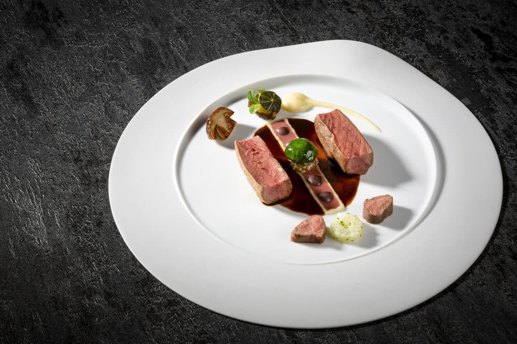 Gebratener Rehrücken mit Topinambur, schwarzer Arágon Olive und Zitronenmyrte-Jus