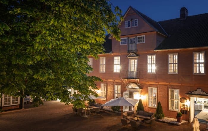 Stimmungsvolle Abendaufnahme vom Hotel Fürstenhof in Celle mit Blick auf die Hofterrasse