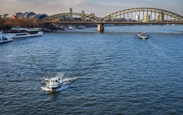 Luftbild Blick über den Rhein auf die Hohenzollernbrücke in Köln im Sommer im Vodergrund ein Motorboot
