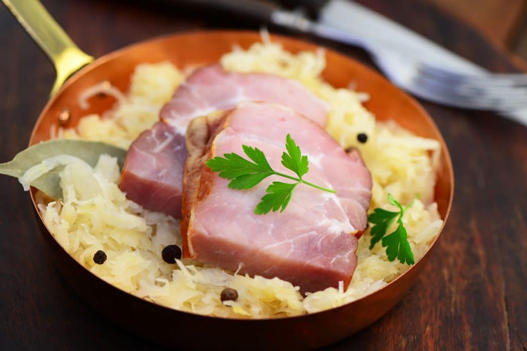 Rippchen mit Kraut Schweinerippchen auf Sauerkraut in einem Kupferpfännchen
