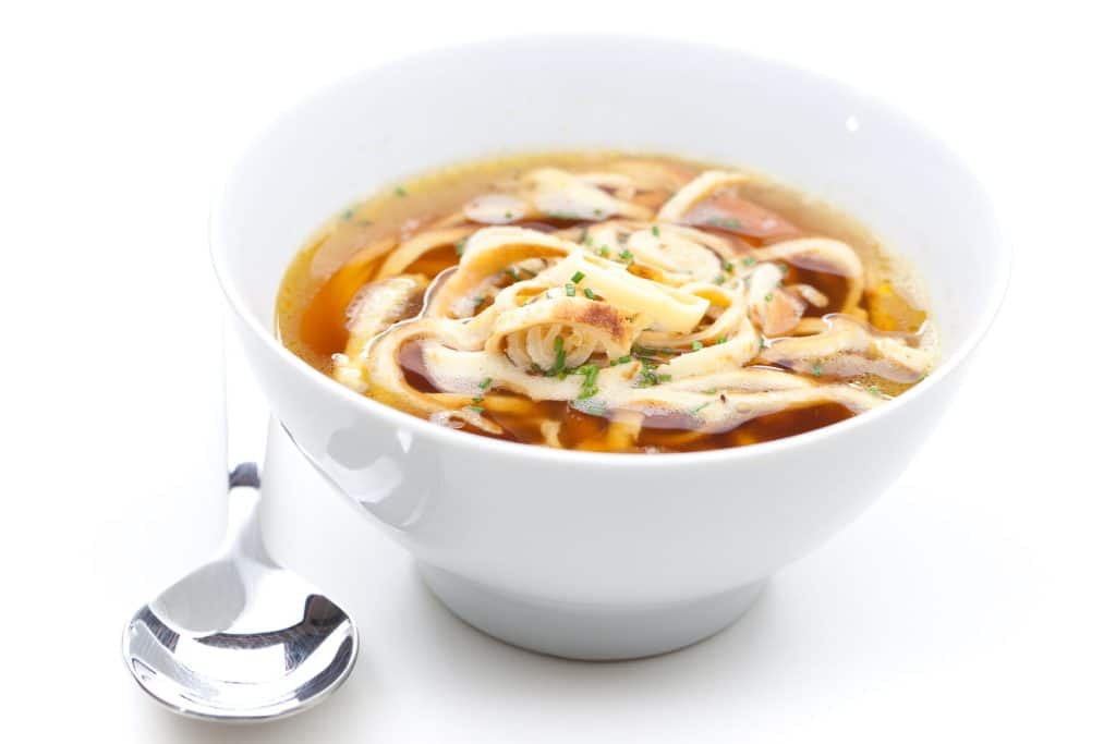 Rindsuppe mit Fritatten und Löffel Brühe, Fritatten, Rindsuppe, Suppe, Löffel, Crepes, Teller, Eierkuchen, Essen, Fettauge, flüssig, Frittatten, klar, klare, Krepp, Omelett, Palatschinken, Pfannkuchen, Rindssuppe, weiß, Hintergrund, Einlage, Schnittlauch, ein, eine, Schüssel