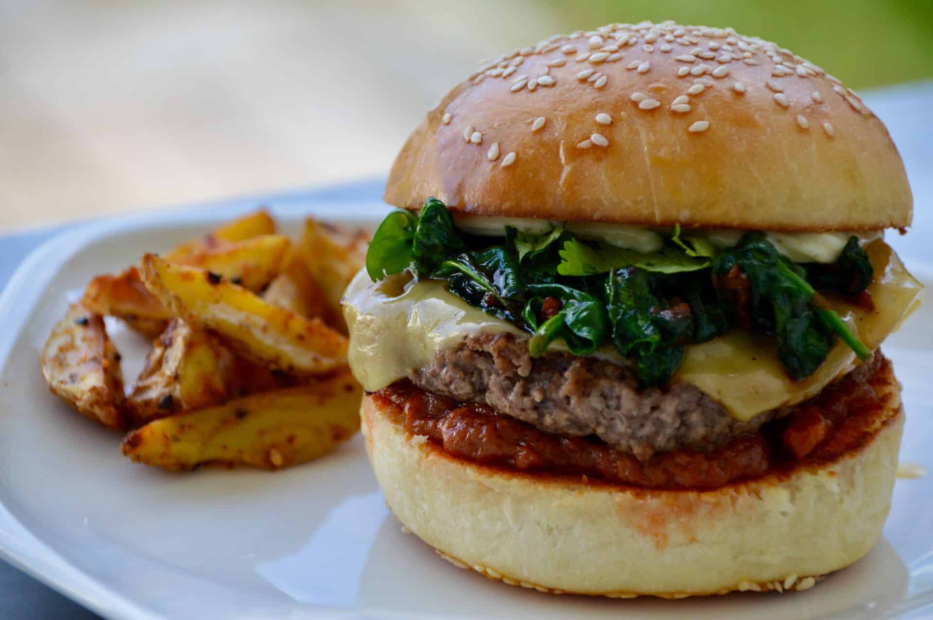 Thai-Style Burger mit Pommers auf einem Teller servierfertig