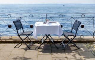 Tisch für 2 mit weißer Tischdecke am Seeuferterrasse am Bodensee
