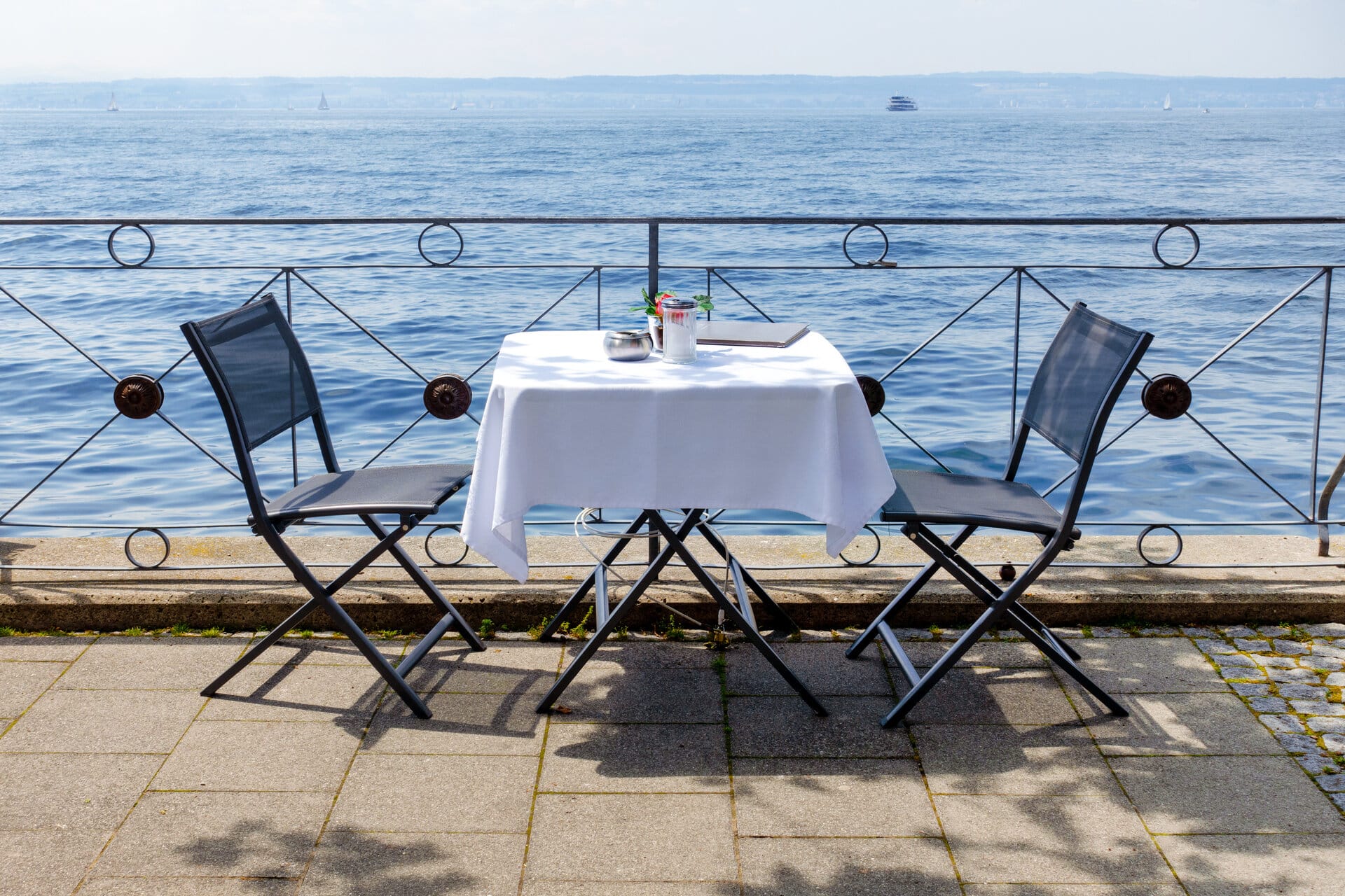 Tisch für 2 mit weißer Tischdecke am Seeuferterrasse am Bodensee