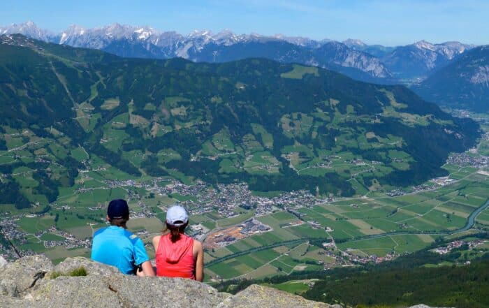 Wanderpaar bei einer Rast mit Aussicht auf das Zillertal