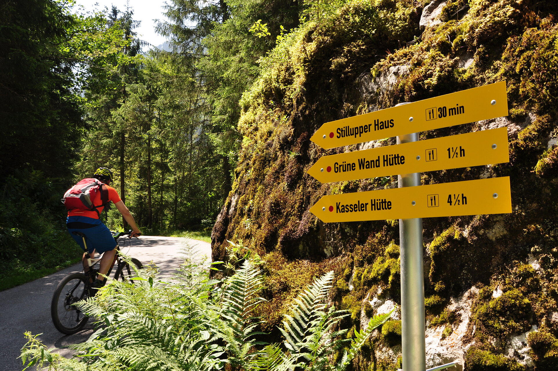 Radfahrer im Stilluptal / Zillertal Heruntergeladen Radfahrer im Stilluptal / Zillertal fährt an 3 Wegweisern vorbei, die auf 3 Berghütten verweisen: Silluper Haus, Grüne Wand Hütte und Kasseler Hütte