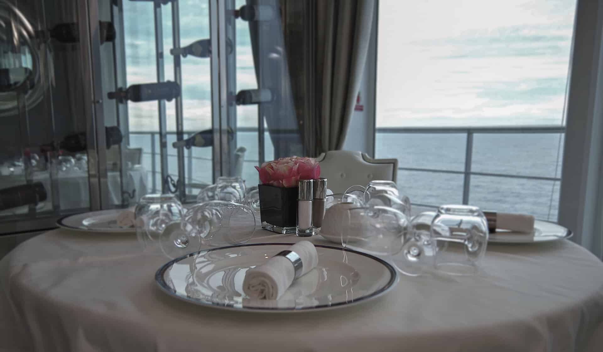 eingedeckter runder Tisch am Fenster auf einem Kreuzfahrtschiff