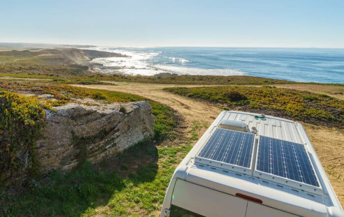 Camper mit Solarpanel auf dem Dach am Strand