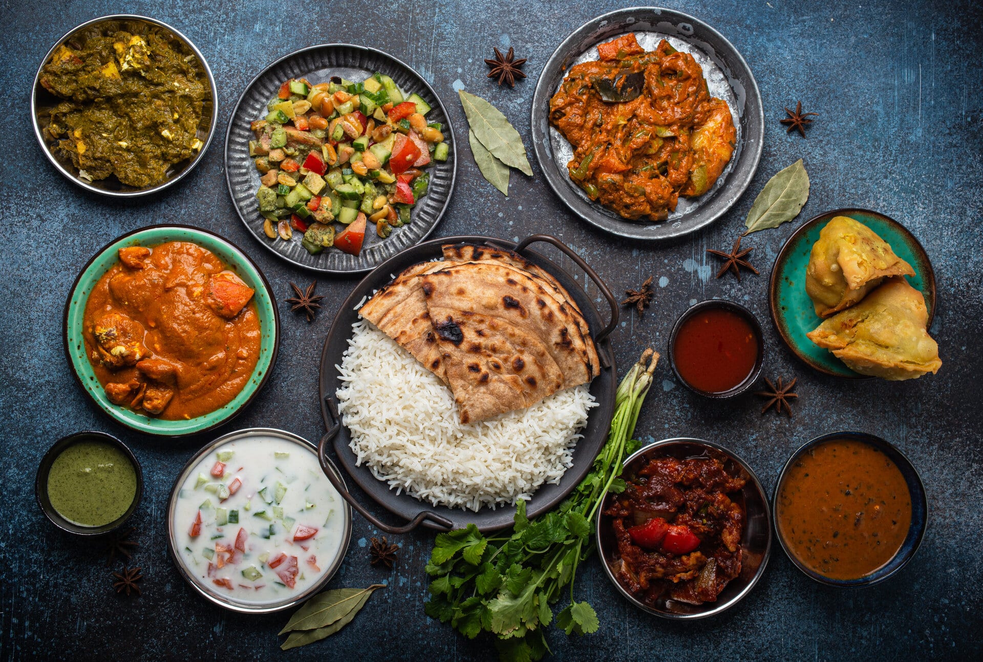 eine Auswahl an indischen ayurvedischen Gerichten in runden schälchen auf grauem Hintergrund.