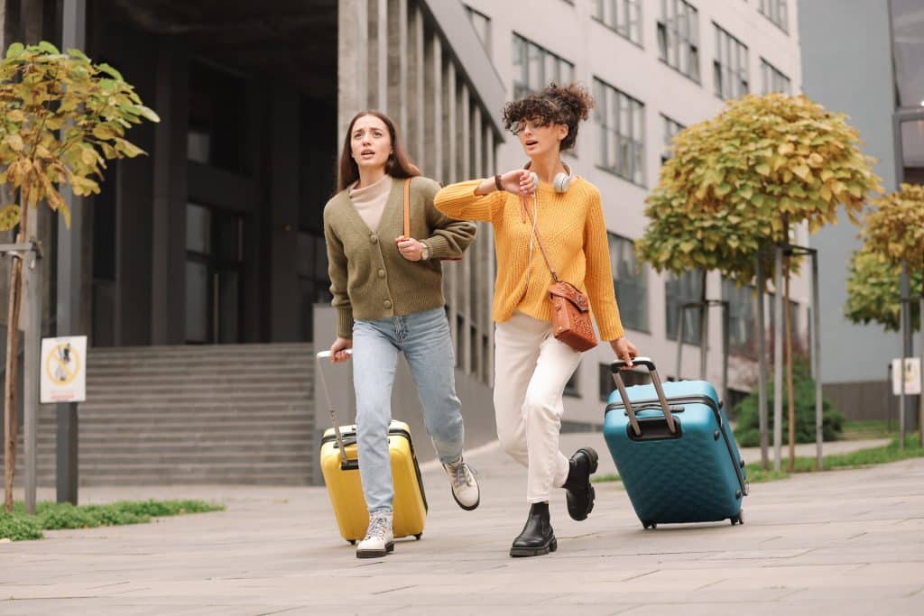 Being late. Worried women with suitcases running outdoors