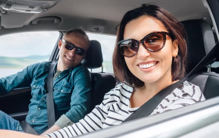 Fröhlich lachendes Paar sitzt im Auto